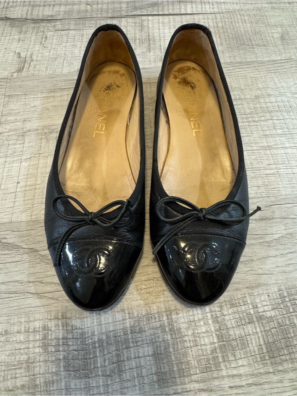 CHANEL Black Leather Ballet Flats with Patent Cap Toe and Bow